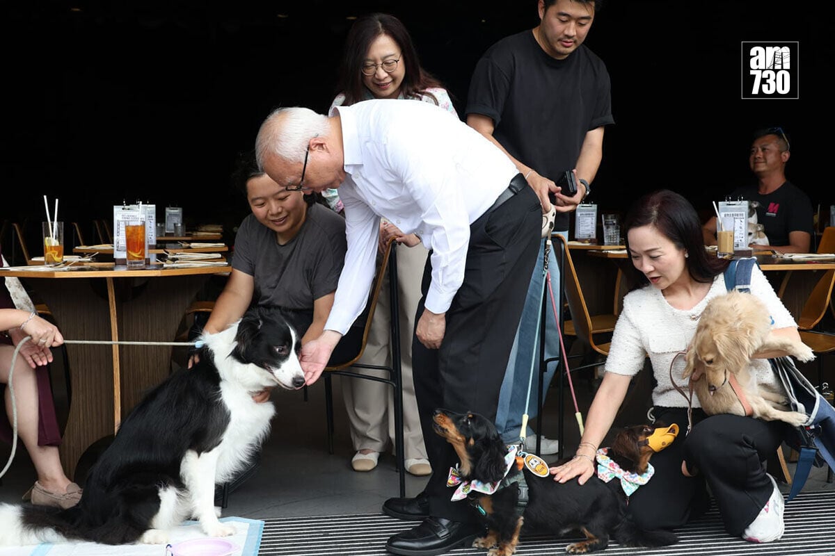 謝展寰(右二)及陳凱欣(右一)視察一間食肆首日准許狗隻進入的情況。(周令知攝)