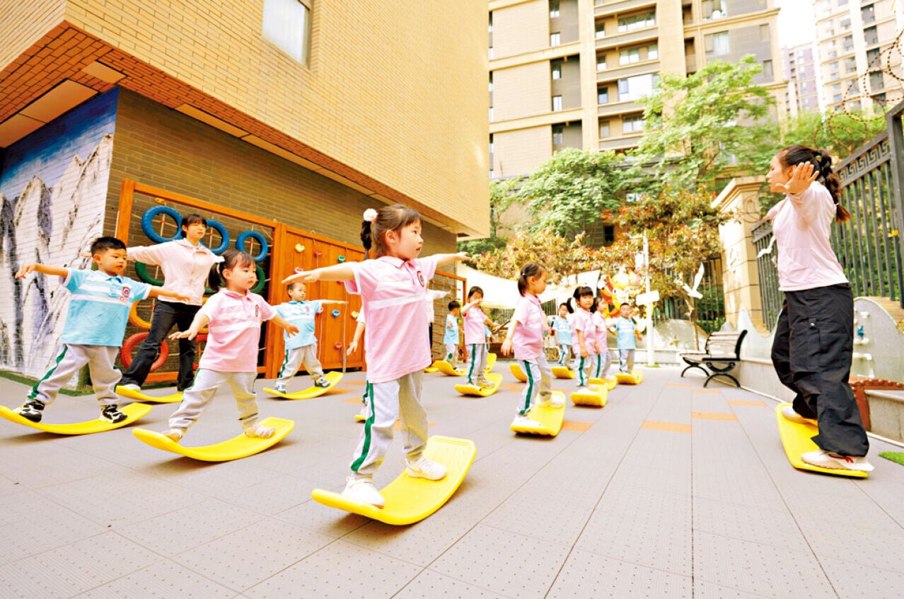 西安市有幼兒園的學童在老師引導下做平衡板訓練。 (新華社)