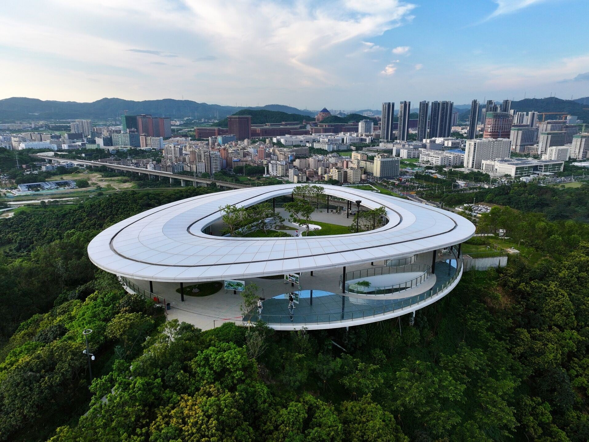 深圳地鐵13號線北延段沿線景點:科學公園是深圳最大的城市公園。園內地標「光明頂」環廊周長156.1米,平台提供360°環繞視野,可俯瞰科學城全景。腳下「天空之鏡」玻璃地面倒映天色,是打卡好去處。(圖片來源:視覺中國)