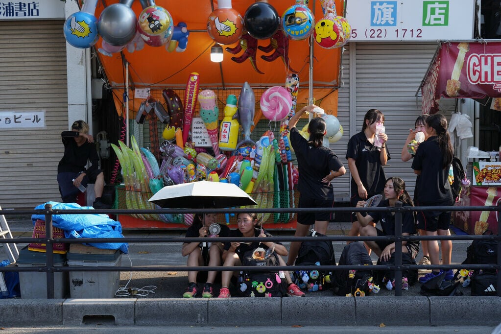 日本熊谷市天氣炎熱,不少人開遮擋太陽(AP)