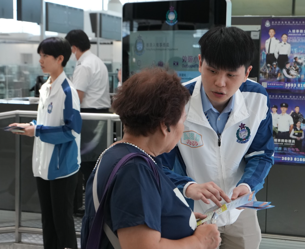 入境處在香港國際機場派發傳單,提醒市民外遊時、尤其是暑假期間的旅遊旺季的注意事項。(入境處提供)
