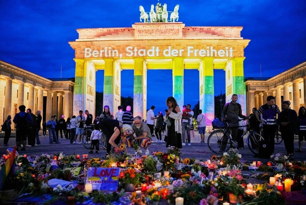 人們聚集在勃蘭登堡門外悼念死傷者及支持 LGBTQ+ 群體。(AP)