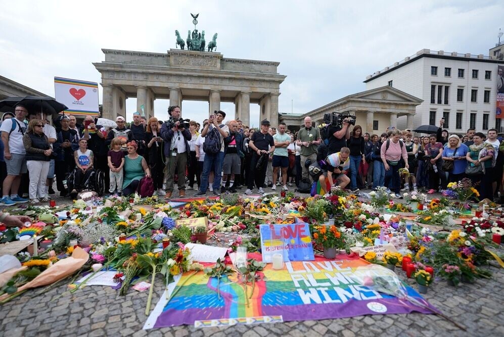 人們聚集在勃蘭登堡門外悼念死傷者及支持 LGBTQ+ 群體。(AP)
