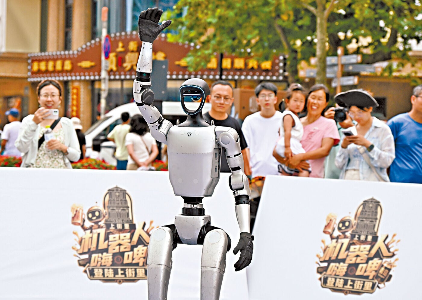 一個人形機械人上周三在青島國際啤酒節老城會場與遊人互動。(新華社)