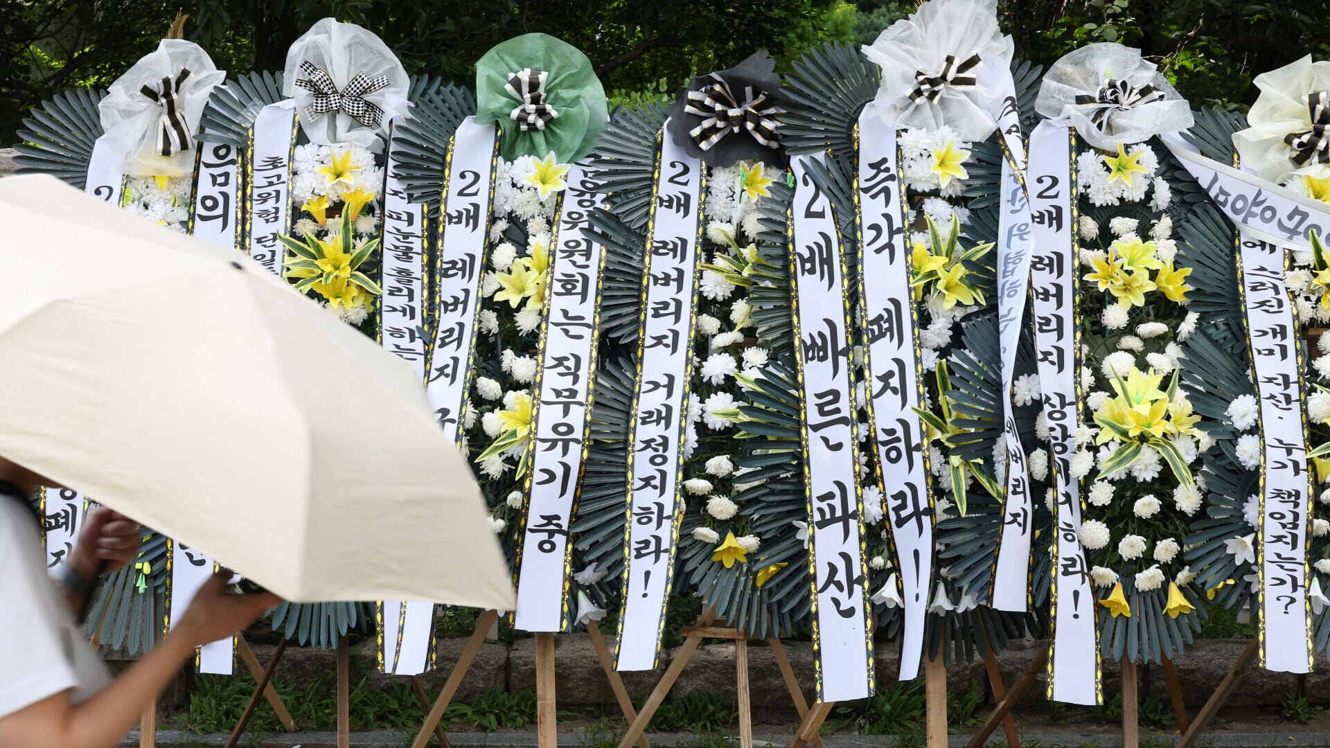 南韓有股民團體發起抗議，向國會大樓致送多個弔唁花圈。(路透社)