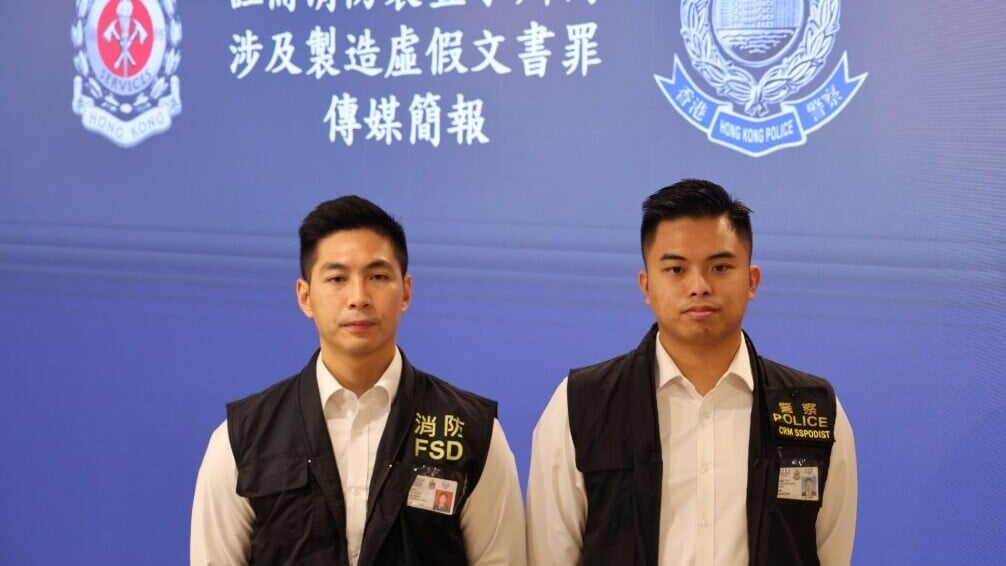 圖為消防處署理助理消防區長（消防工程合規）蔡列邦（左）、警務處深水埗警區刑事調查隊第五隊督察呂澤鈞（右）。(中通社)