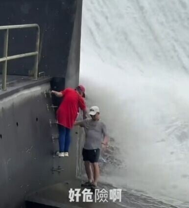 一名男子已走到水壩底部位置,另一名女子亦爬梯跟隨到水壩底部。(FB/全港違例抄牌提示區)