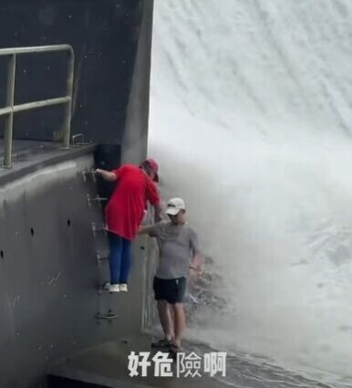 一名男子已走到水壩底部位置,另一名女子亦爬梯跟隨到水壩底部。(FB/全港違例抄牌提示區)