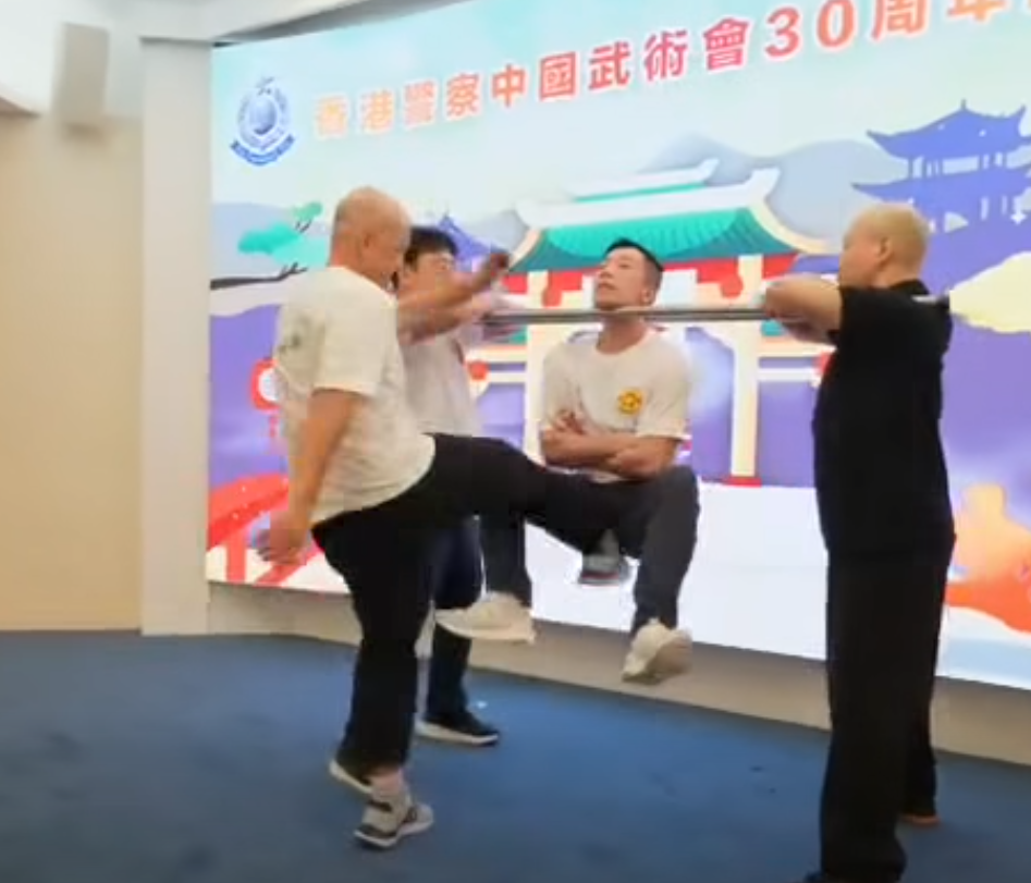 香港警察中國武術會舉行「三十周年會慶暨名譽會長就職典禮」晚宴,有成員表演中國傳統武術中的「鐵襠功」,用頸力懸空被人用腳踢下陰10下。(影片截圖)