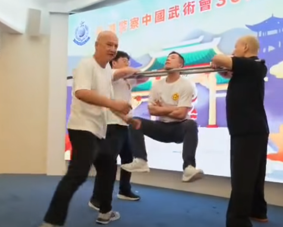 香港警察中國武術會舉行「三十周年會慶暨名譽會長就職典禮」晚宴,有成員表演中國傳統武術中的「鐵襠功」,用頸力懸空被人用腳踢下陰10下。(影片截圖)