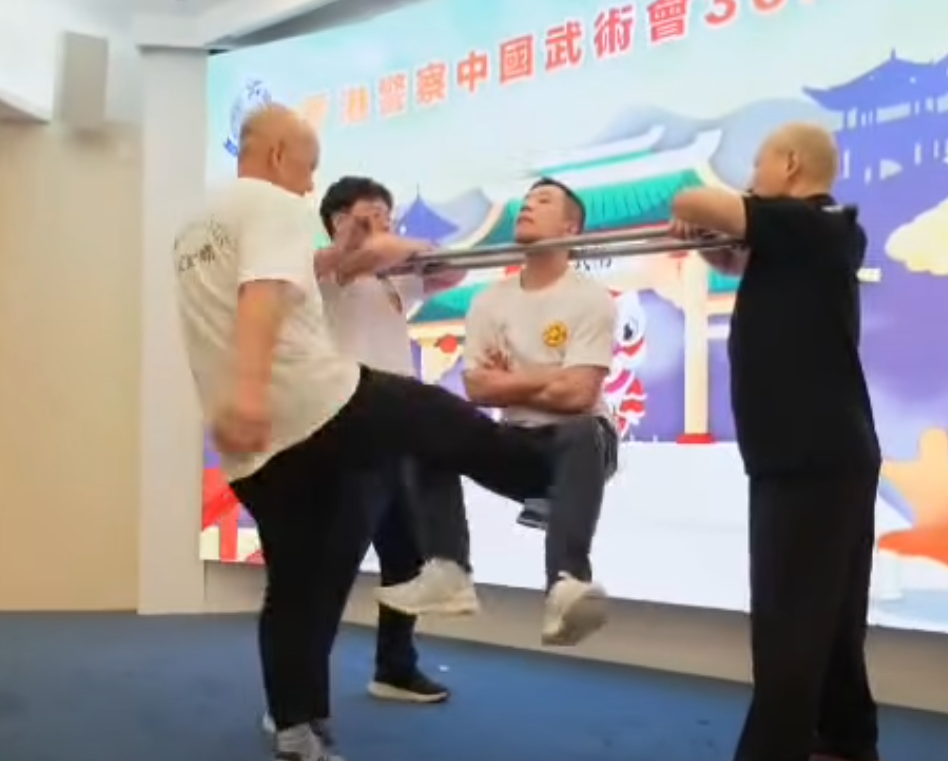 香港警察中國武術會舉行「三十周年會慶暨名譽會長就職典禮」晚宴,有成員表演中國傳統武術中的「鐵襠功」,用頸力懸空被人用腳踢下陰10下。(影片截圖)