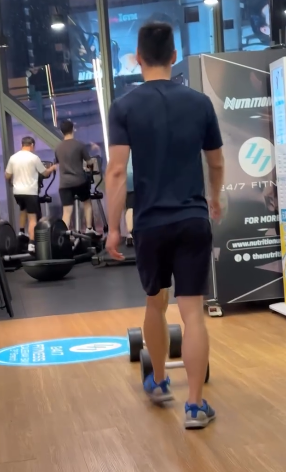 一名男顧客在一間連鎖健身中心「24/7 FITNESS」的銅鑼灣分店內,將一個重30kg的啞鈴用腳來回推動。(Threads)