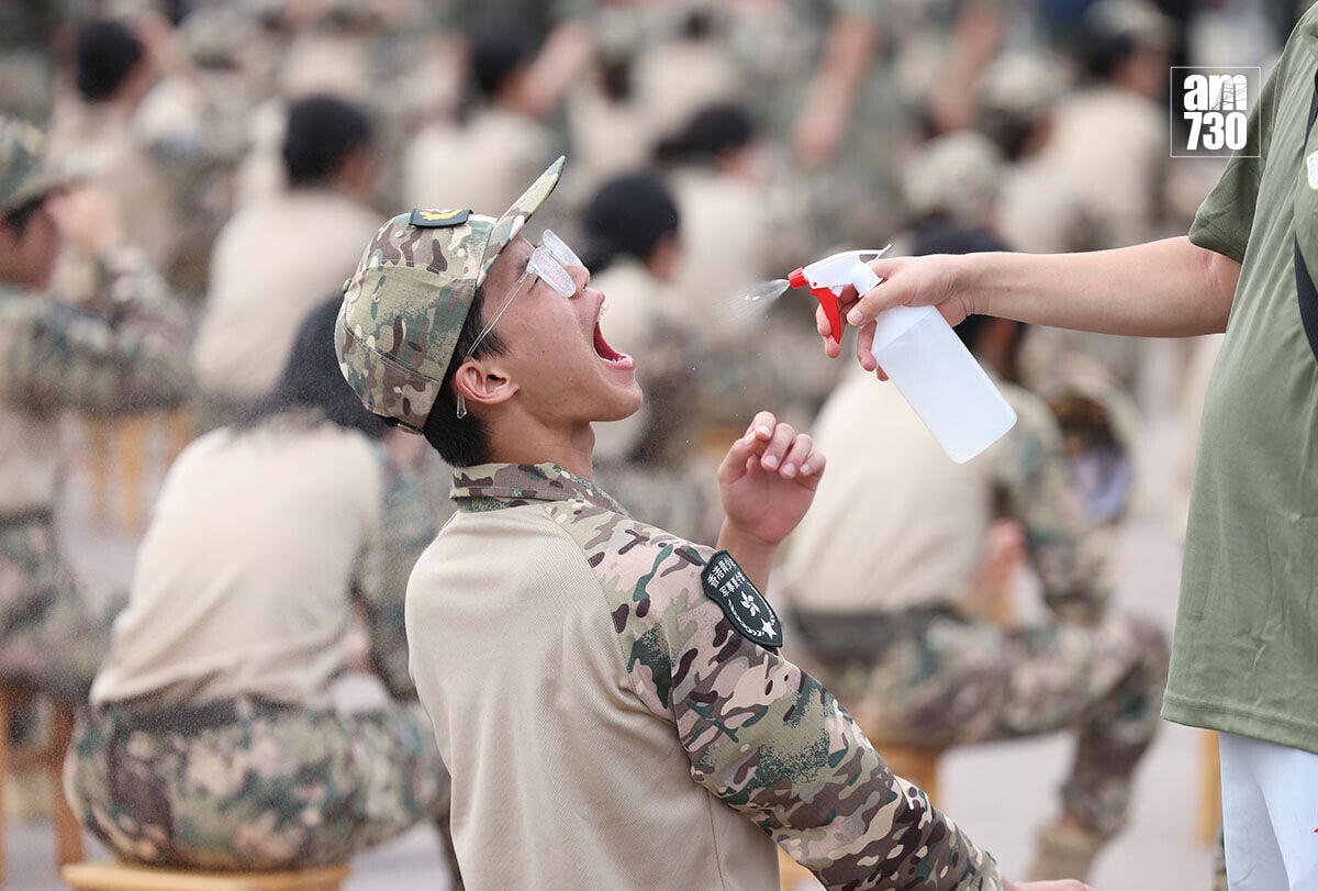 駐港解放軍青少年軍事夏令營暨大學生軍事生活體驗營舉行開營儀式,期間有輔導員為學員噴水降溫。(中通社)