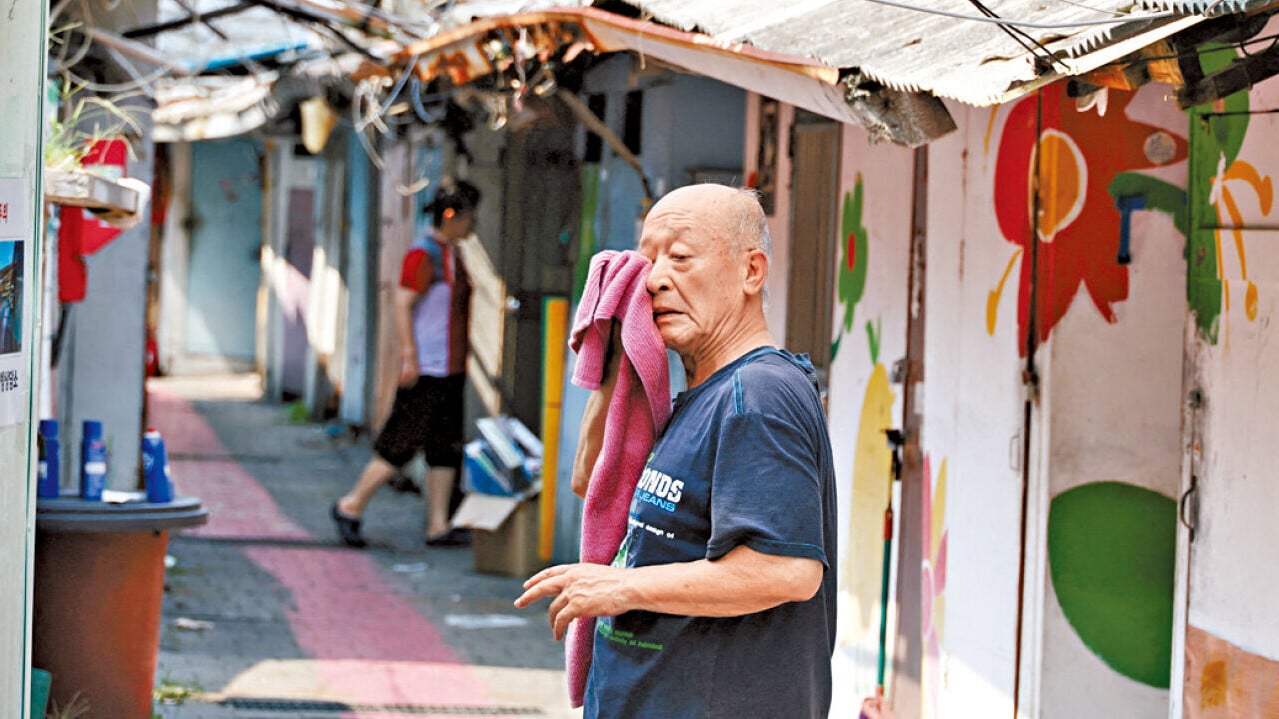 首爾一名男居民熱得不住抹汗。(路透社)