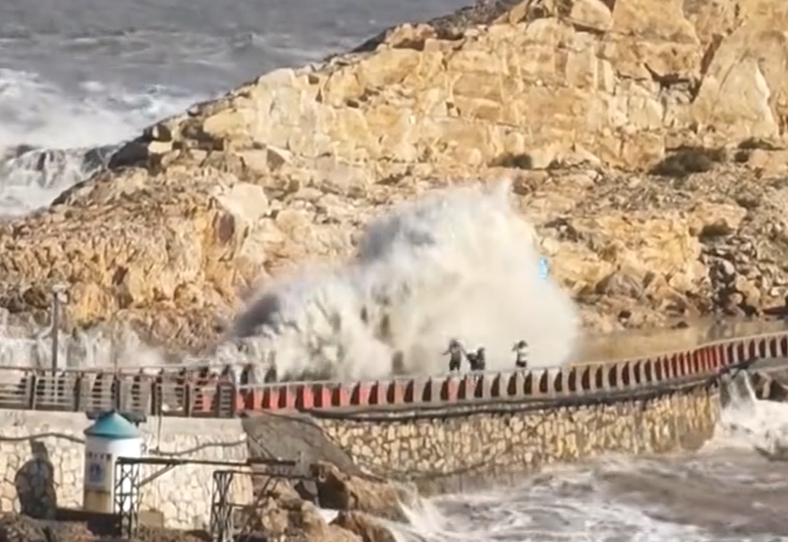 因防颱封閉的浙江台州溫嶺石塘大壩,遭4名外地遊客不顧當地民眾勸阻擅闖觀浪,導致1名9歲男童遭巨浪捲走(影片截圖)