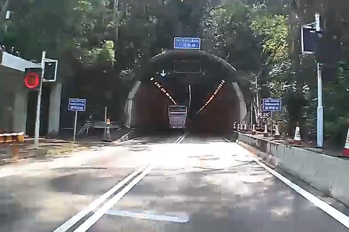 城門隧道一輛旅遊巴懷疑71歲司機病發暈倒,撞向路旁石壆始停下。(網上影片截圖)