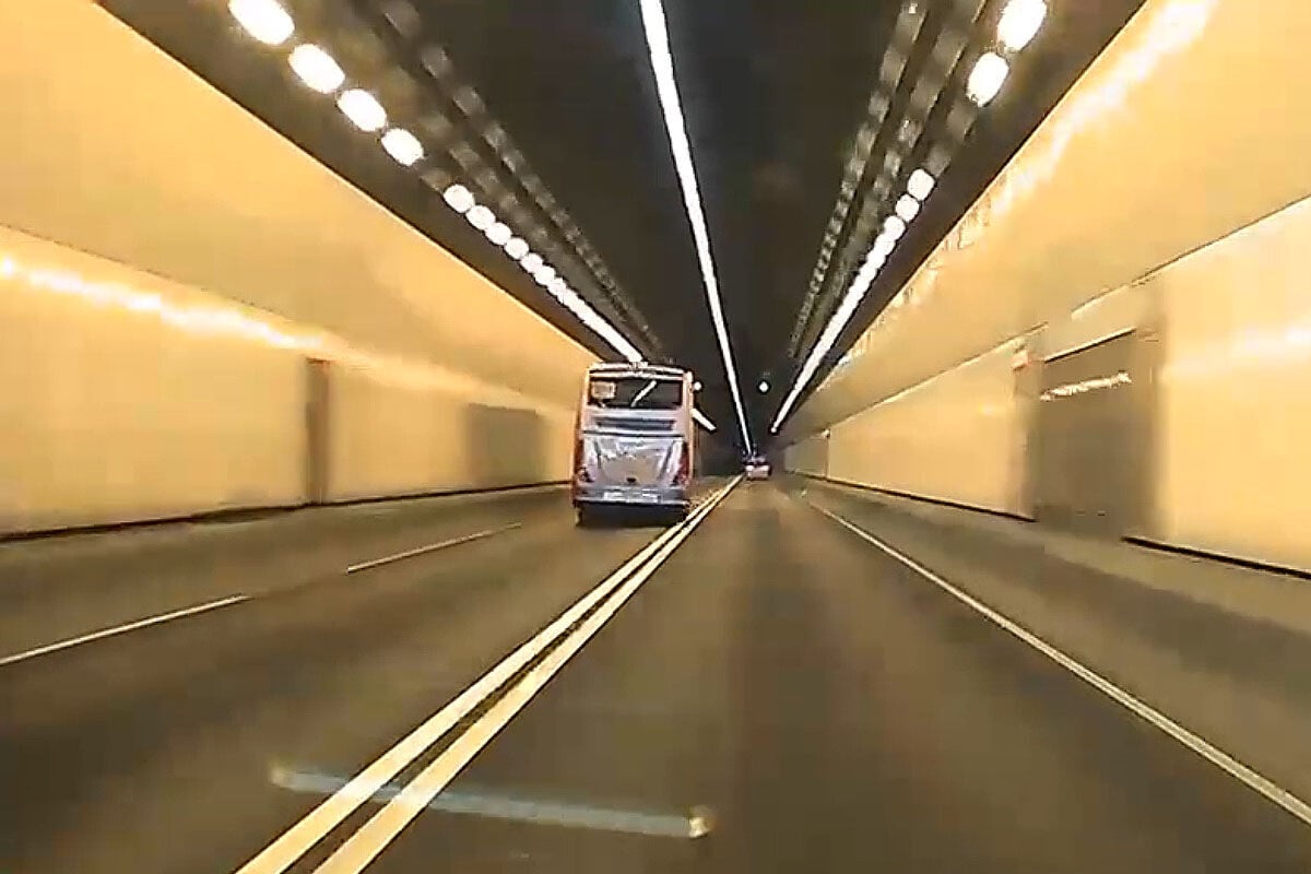 城門隧道一輛旅遊巴懷疑71歲司機病發暈倒,撞向路旁石壆始停下。(網上影片截圖)