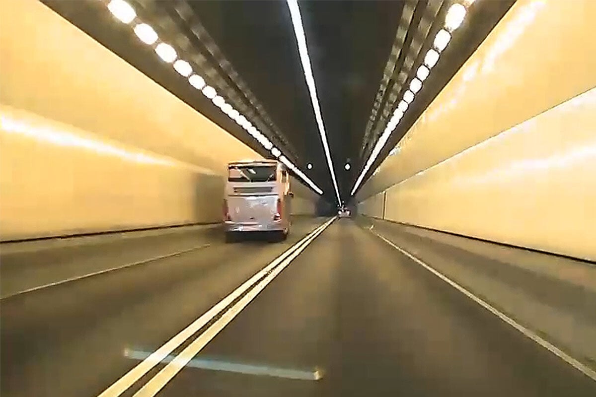城門隧道一輛旅遊巴懷疑71歲司機病發暈倒,撞向路旁石壆始停下。(網上影片截圖)