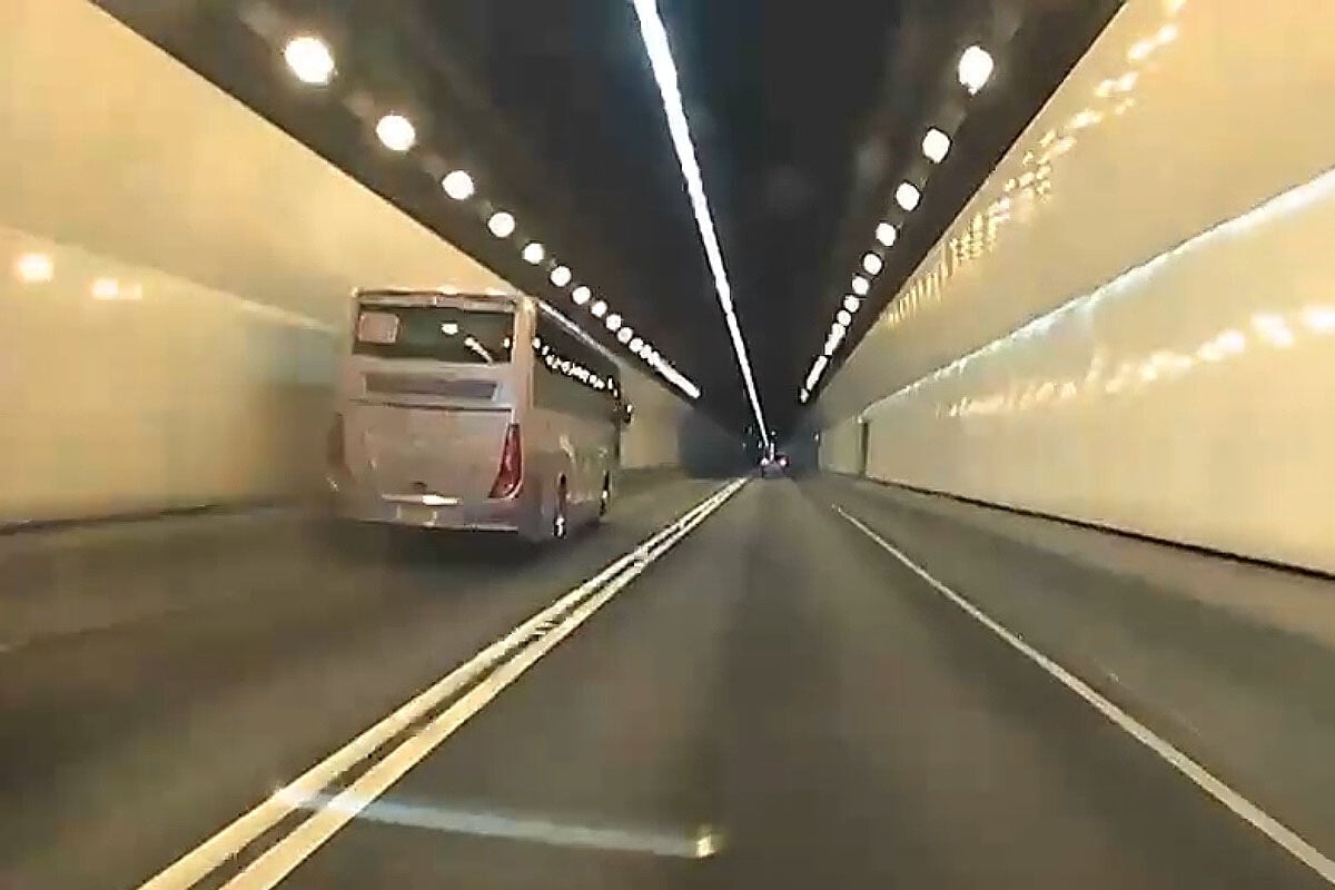 城門隧道一輛旅遊巴懷疑71歲司機病發暈倒,撞向路旁石壆始停下。(網上影片截圖)