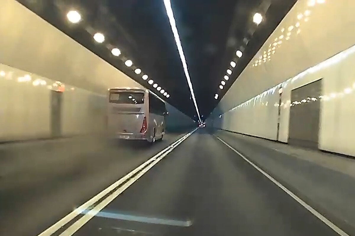 城門隧道一輛旅遊巴懷疑71歲司機病發暈倒,撞向路旁石壆始停下。(網上影片截圖)