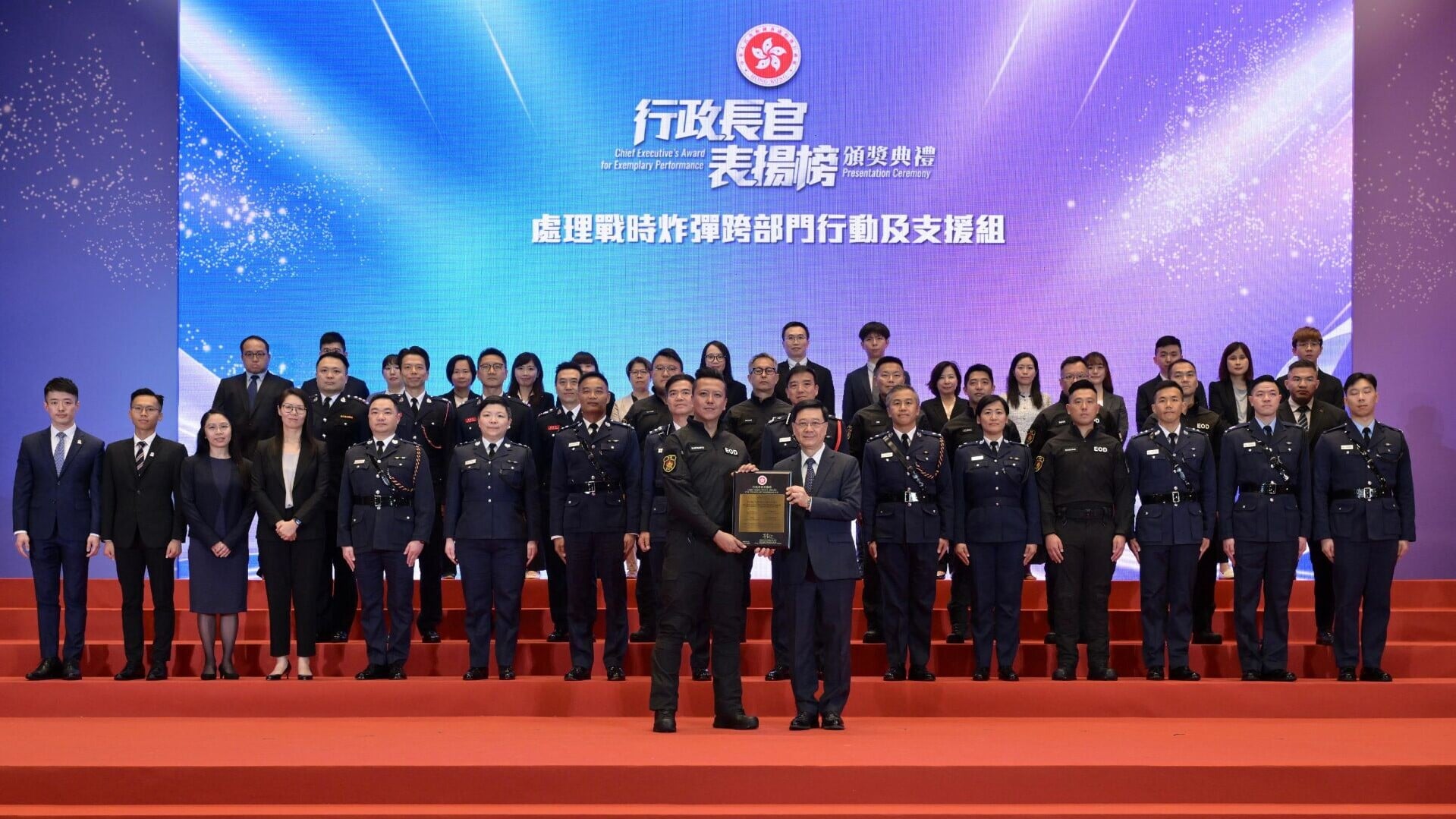 行政長官李家超在「行政長官表揚榜」頒獎典禮上向「處理戰時炸彈跨部門行動及支援組」頒授獎狀。圖示李家超（前排右）向香港警務處高級炸彈處理主任（爆炸品處理課）李展超（前排左）頒授獎狀。