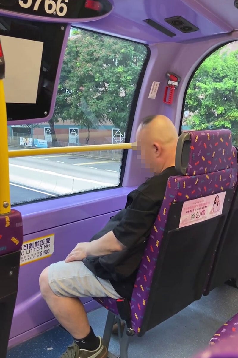 一名男子在巴士車廂內,旁若無人地用電剪修剪頭髮。(網上影片截圖)