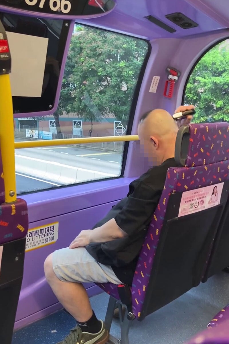 一名男子在巴士車廂內,旁若無人地用電剪修剪頭髮。(網上影片截圖)