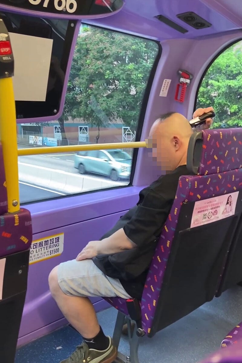 一名男子在巴士車廂內,旁若無人地用電剪修剪頭髮。(網上影片截圖)