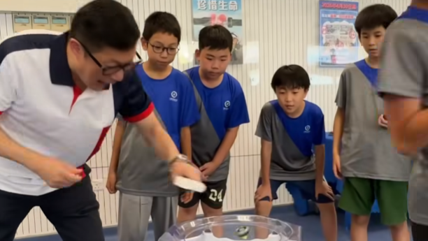 鄧炳強出席「少年警訊夏令營2026」開展禮，其間與一班少訊成員玩陀螺(鄧炳強fb)