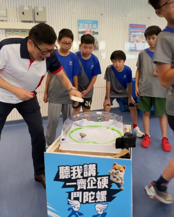 鄧炳強出席「少年警訊夏令營2026」開展禮,其間與一班少訊成員玩陀螺(鄧炳強fb)