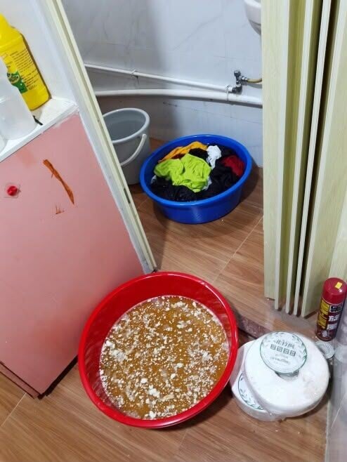 地上擺放着工具及兩個大膠盤,當中分別載有刺鼻液體,浸泡住一大批衣服及其他化學物質。