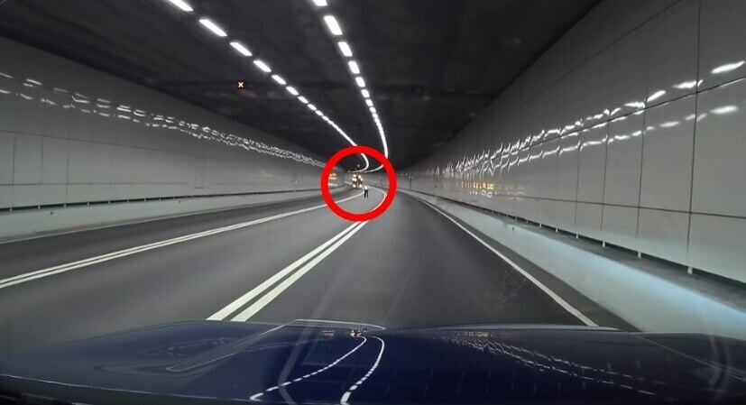 身穿反光衣的職員尾隨,前方則有一輛工程車停下閃燈。(FB/車cam L(香港群組))