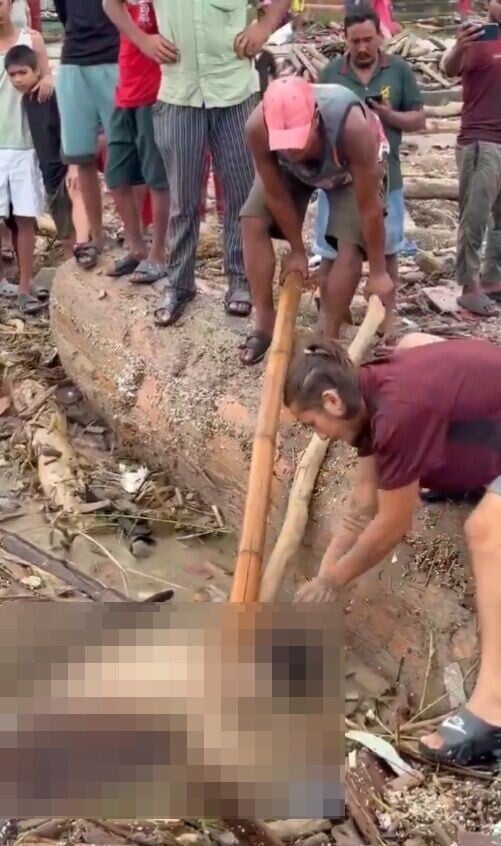 兩名男子卻蹲岸邊,一個用竹杆固定死者位置,另一人俯身伸手到死者身上取下金耳環。(X)