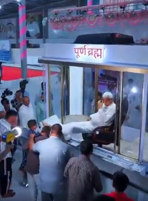 Sant Rampal Ji Maharaj一邊涼著冷氣,一邊讓信徒排隊靠近親吻和觸摸他的腳以接受祝福。(X)