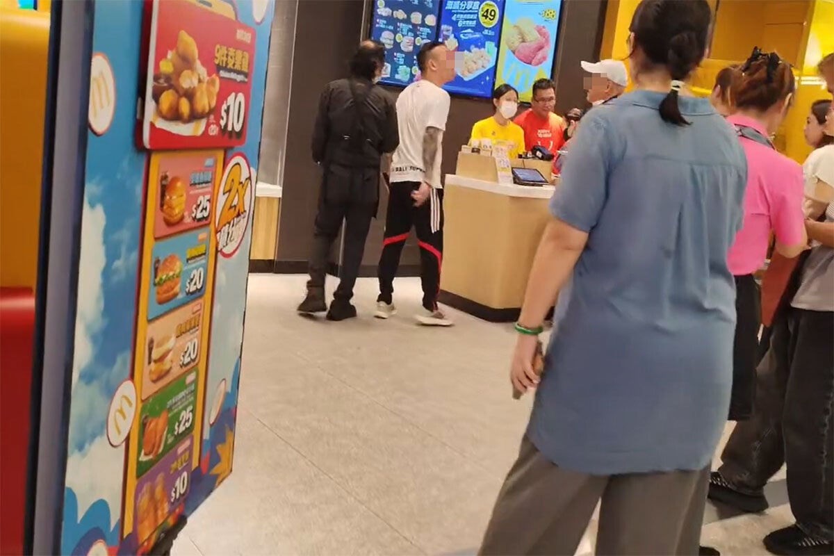 將軍澳一間麥當勞日前有兩名顧客口角,其中白衣男事後涉嫌自稱三合會成員被捕。(網上影片截圖)