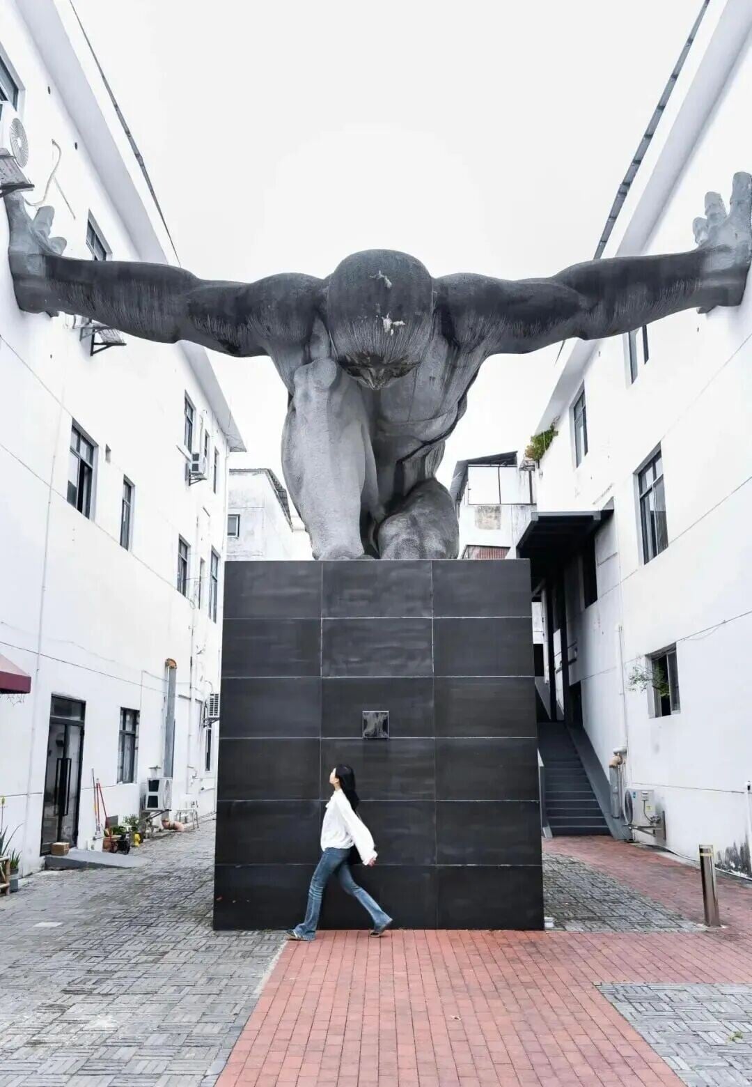 坪山藝術創意園必去的,是位於A1、A2兩樓之間的巨人雕塑《橋》,巨人雙臂撑開建築間隙的姿態,有連結與跨越的深意。(圖片來源:坪山雕塑藝術創意園微信)