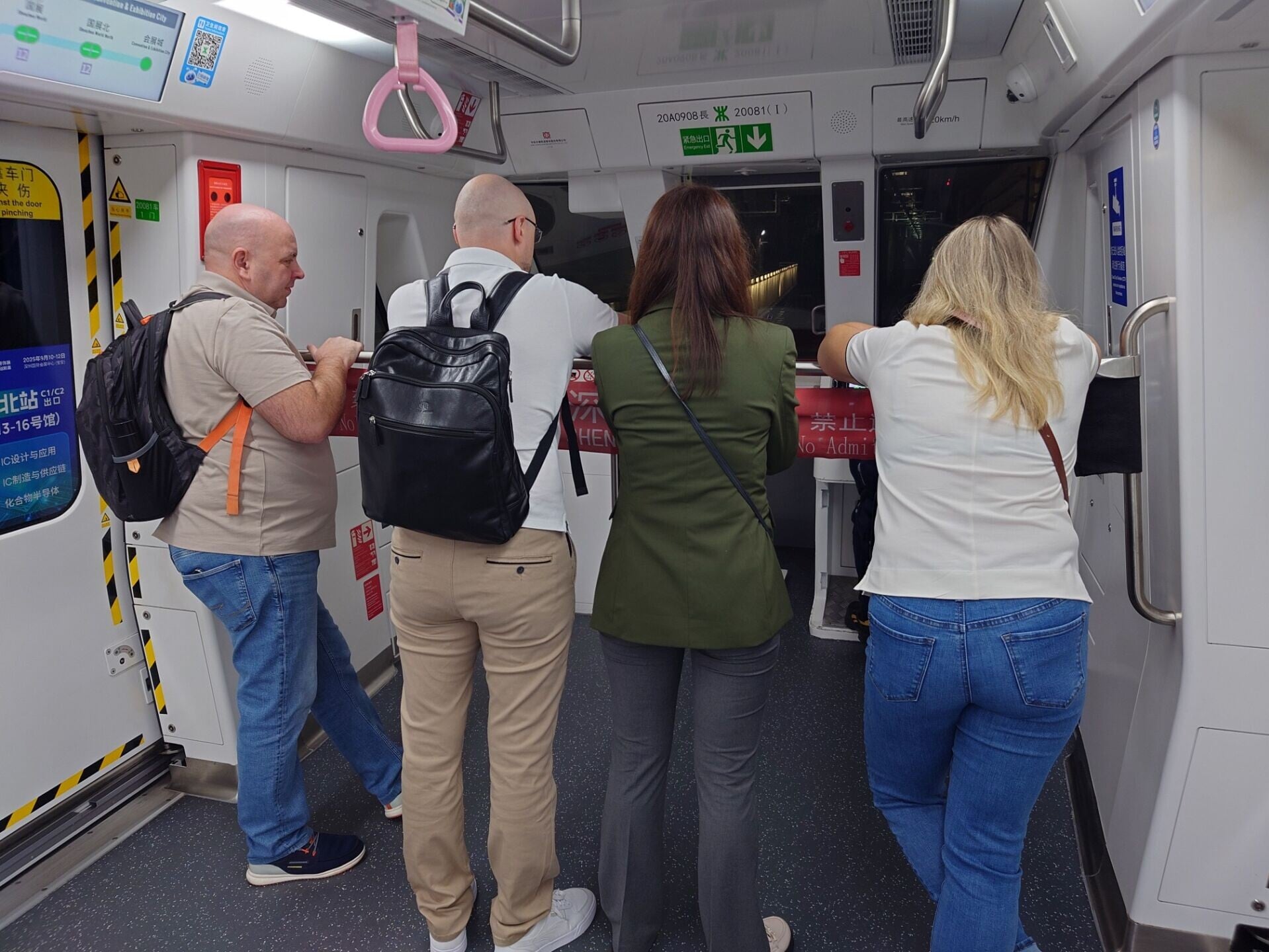 外籍遊客擠在車頭,目不轉睛盯着無人駕駛列車在隧道內飛馳。(圖片來源:視覺中國)
