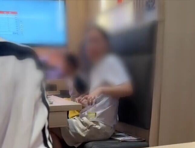 小孩家長手上的透明膠杯內疑為小孩尿液