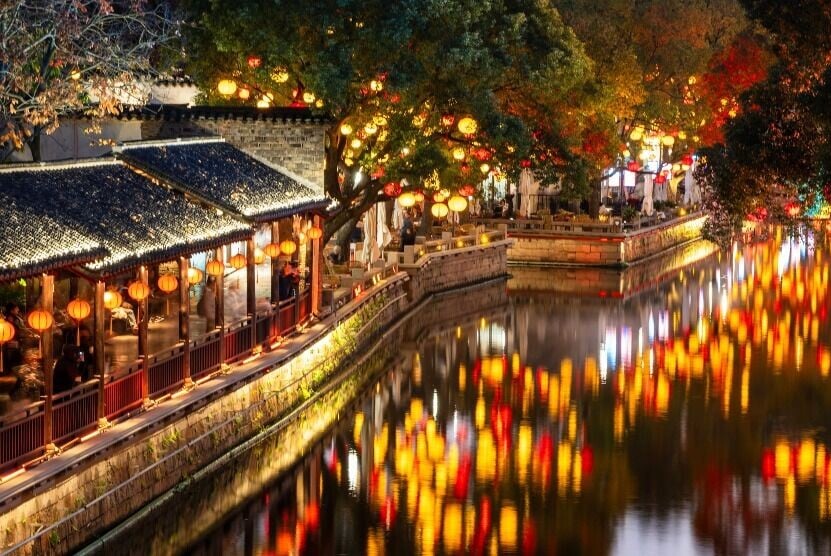 夜色降臨後,惠山古鎮紅黃燈籠沿河高掛,暖光倒映在的水面,猶如流動的星光。(圖片來源:視覺中國)