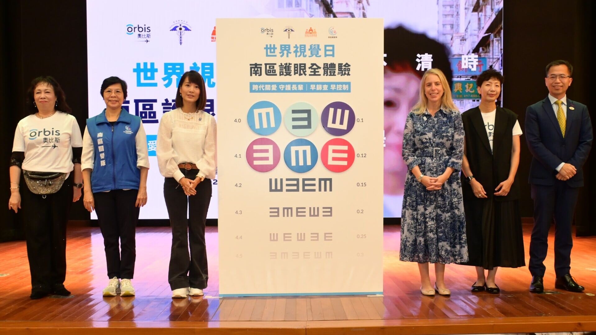 Photo 1 相片一（聯合啟動儀式）： 國際奧比斯主席兼行政總裁 Kathleen Sherwin 女士（右三）、南區民政事務專員張佩珊太平紳士（左三）、香港眼科學會會長任卓昇教授（右一）、南區關愛隊聯席代表 林玉珍女士BBS MH（左二）、香港奧比斯總幹事劉慧思女士（右二），以及奧比斯「愛眼之星」許思敏女士（左一）一同主持「世界視覺日長者護眼行動」啟動儀式，將彩色「E」字貼上巨型驗眼表，象徵四方攜手為南區長