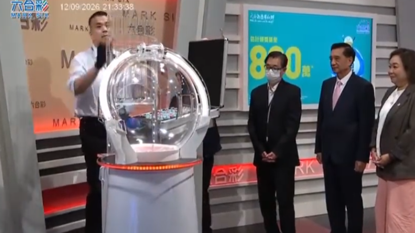 六合彩攪珠機出現罕見故障，沒有號碼球掉落中間管道，須改用後備攪珠機及後備號碼，並由監場嘉賓監察更換過程。(直播畫面)