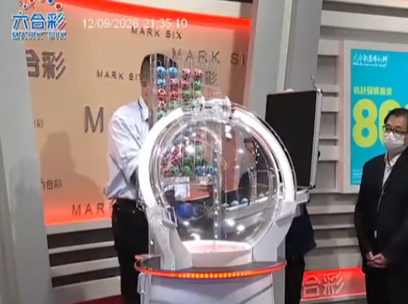 六合彩攪珠機出現罕見故障,沒有號碼球掉落中間管道,須改用後備攪珠機及後備號碼,並由監場嘉賓監察更換過程。(直播畫面)