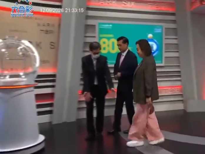 六合彩攪珠機出現罕見故障,沒有號碼球掉落中間管道,須改用後備攪珠機及後備號碼,並由監場嘉賓監察更換過程。(直播畫面)