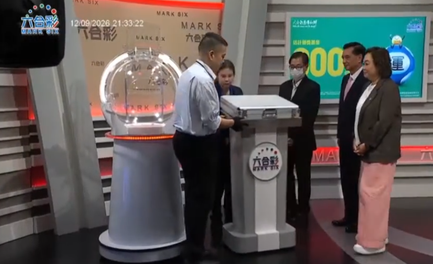 六合彩攪珠機出現罕見故障,沒有號碼球掉落中間管道,須改用後備攪珠機及後備號碼,並由監場嘉賓監察更換過程。(直播畫面)