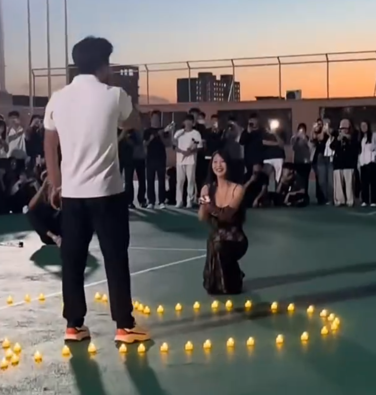 河北石家莊美術學院校園操場,一名女生向男方單膝跪地求婚(微博影片)