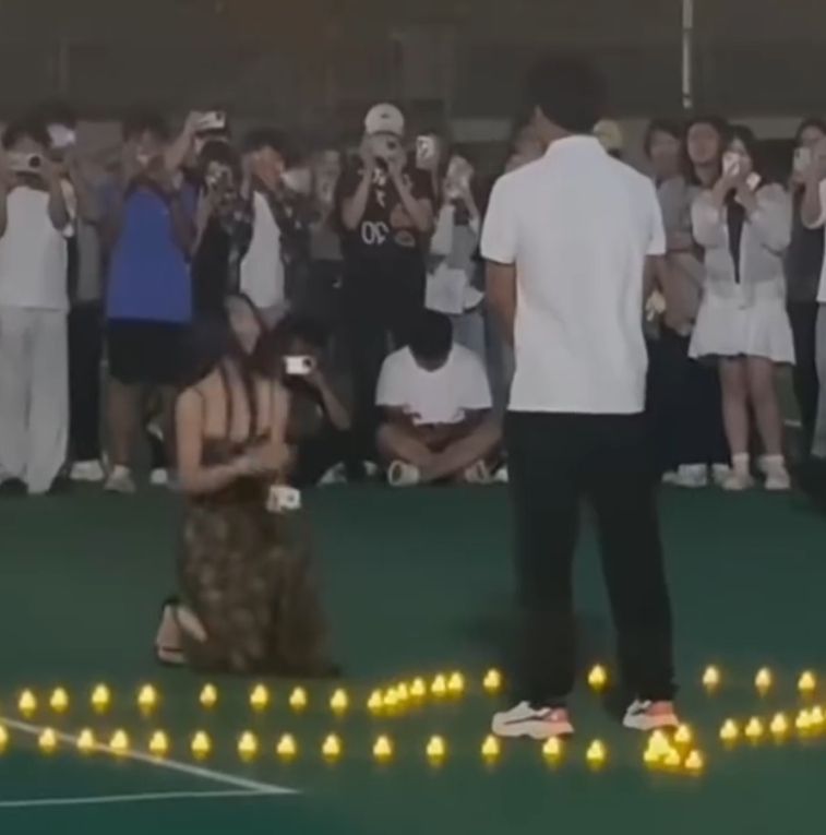 河北石家莊美術學院校園操場,一名女生向男方單膝跪地求婚(微博影片)