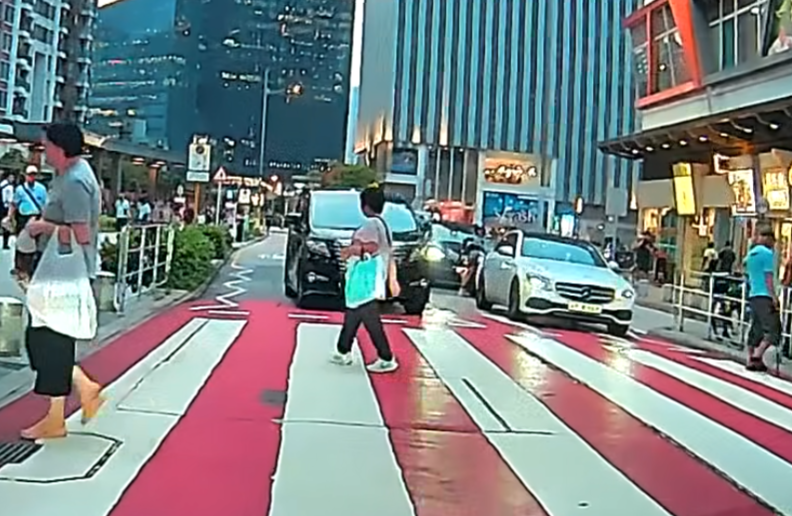 一輛掛兩地牌的七人車駛至啟德沐翠街晴朗商場對開一條斑馬線時疑「趕時間」,突然扭軚切出逆線「爬頭」強行橫越斑馬線。(車cam L(香港群組)fb)