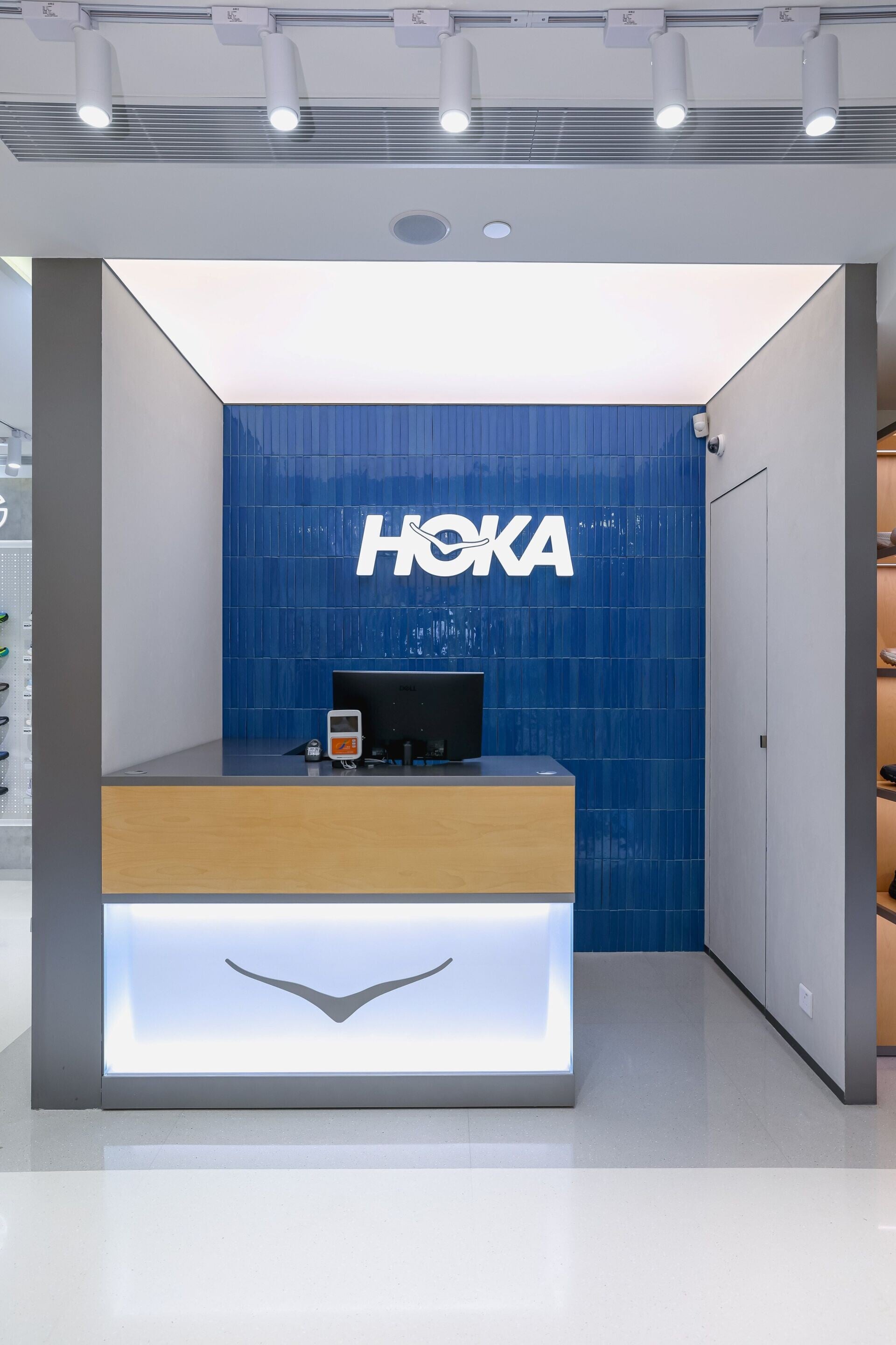 設計亦加入香港城市記憶,店內採用令人聯想到港鐵站的手工釉面磚,表面在燈光下呈現如維港水面的色彩變化,為品牌標誌性的藍色添上本地氣息