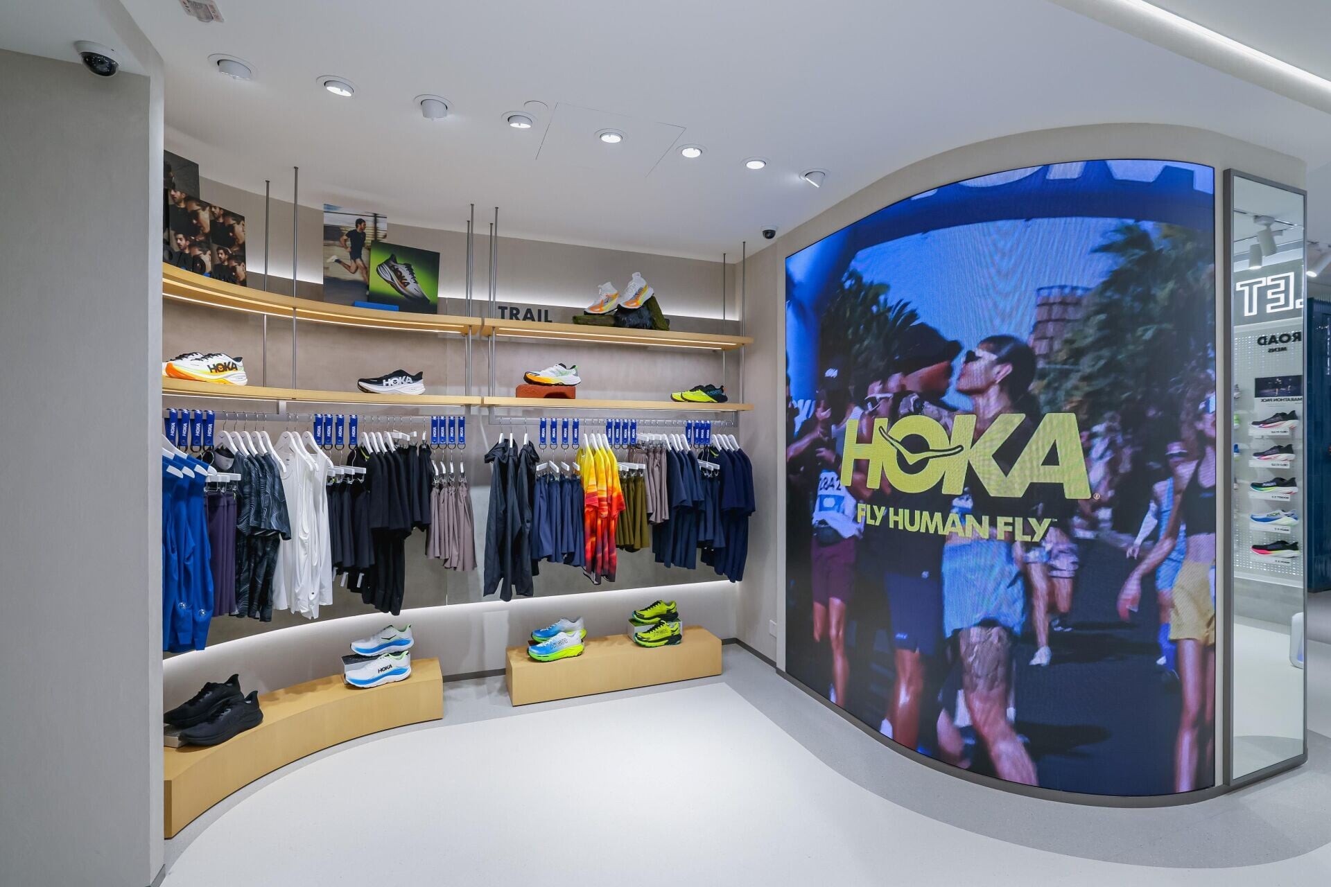 HOKA將城市律動轉化為空間語言,專門店以流暢曲線貫穿門面、牆身及陳列架,靈感源自維港沿岸的水流動態與人體運動線條,柔化空間邊界,讓顧客的目光與步伐自然延展,營造動靜相宜的探索氛圍。