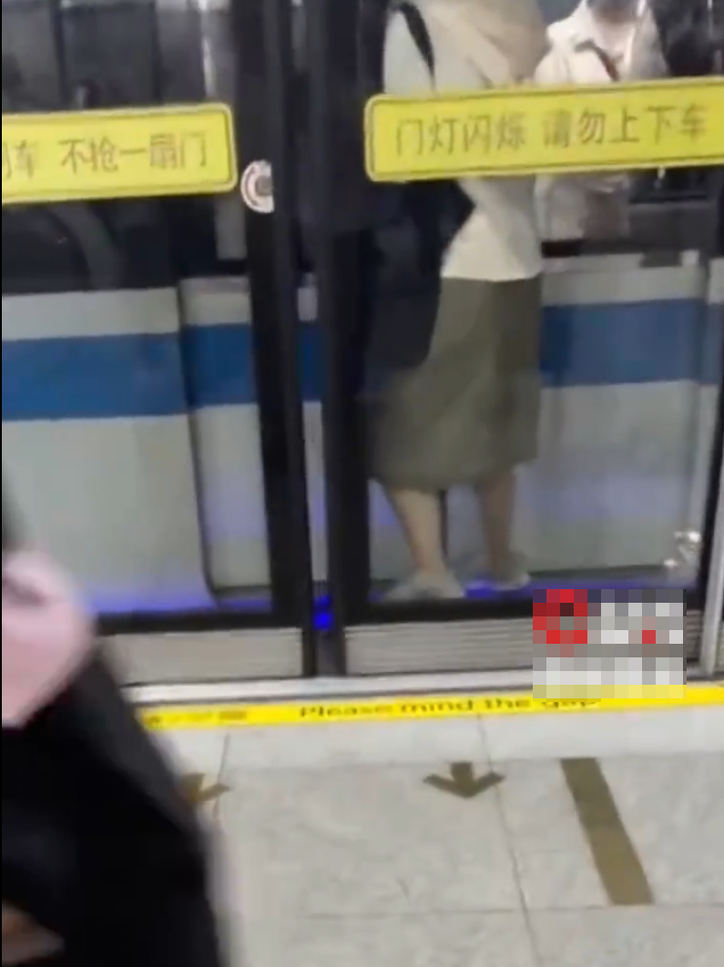 上海地鐵一名女子乘客「衝門」失敗,慘被夾於列車車門與月台幕門之間(影片截圖)